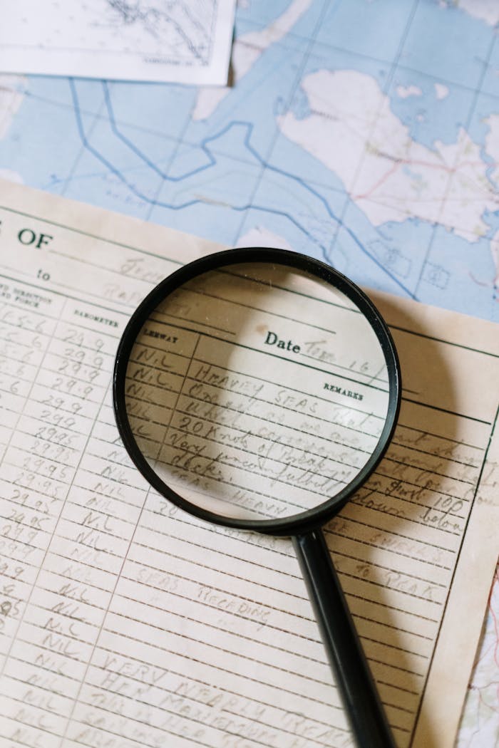 portfolio-05 Close-up of a magnifying glass over a handwritten document on a map.