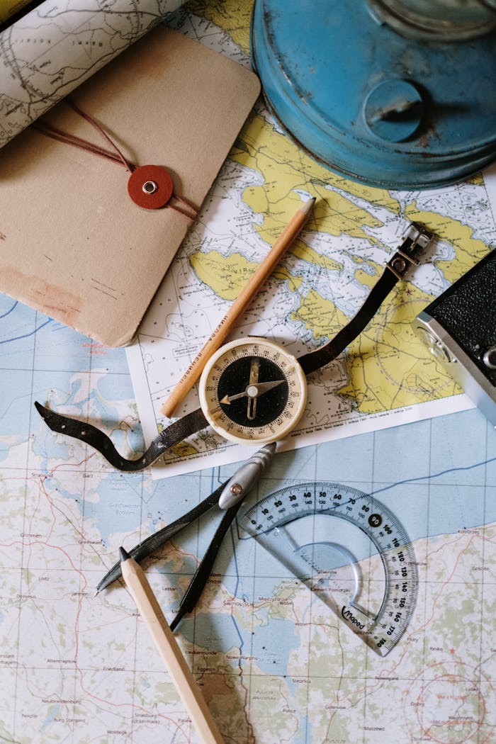 stats-img Flat lay of vintage compass, protractor, and maps for navigation study.